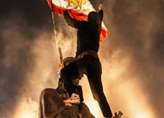 បាតុករអ៊ីរ៉ង់ចាប់ផ្ដើមក្រវីទង់ជាតិនៃរបបរាជានិយមអ៊ីរ៉ង់មុនឆ្នាំ១៩៧៩ខណៈទាញទម្លាក់ទង់ជាតិសាធារណរដ្ឋឥស្លាមអ៊ីរ៉ង់